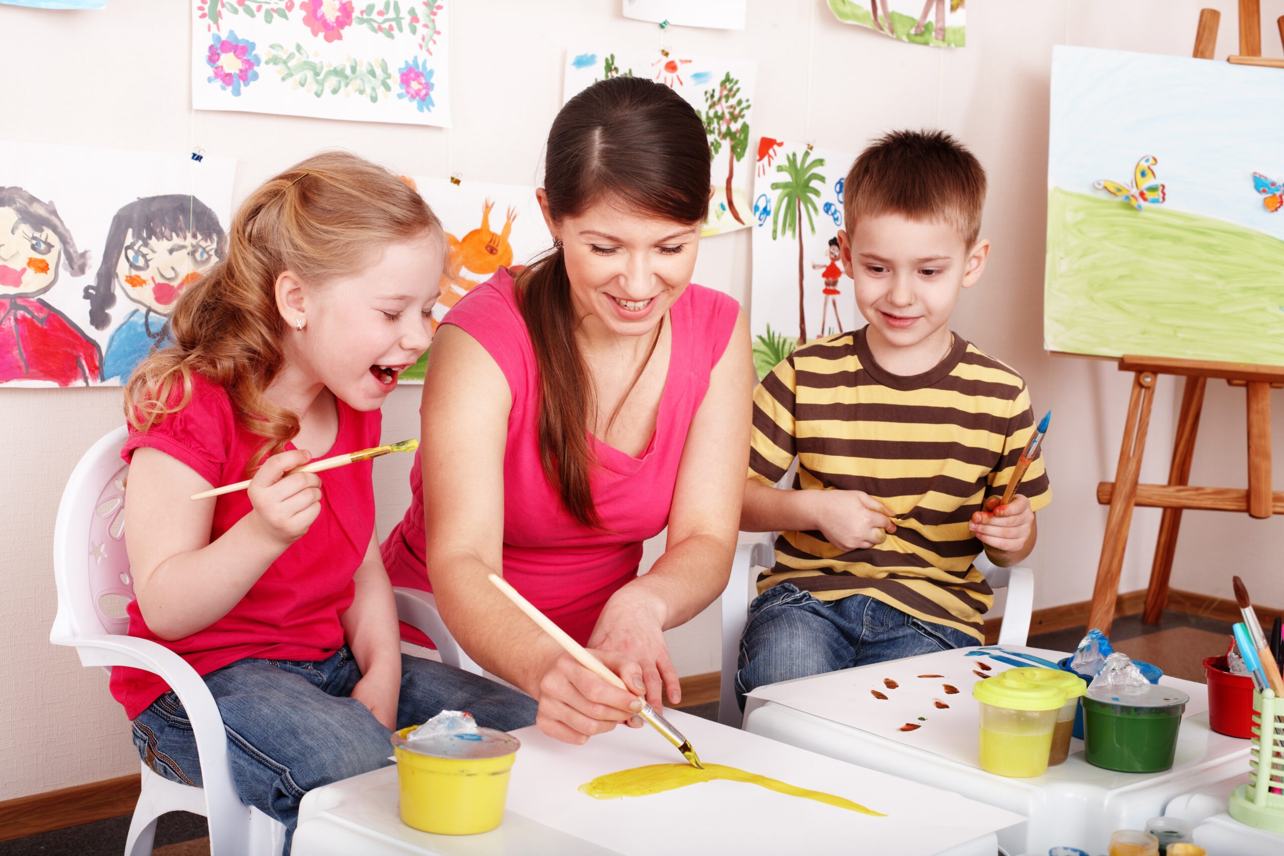 Children With Teacher Draw Paints in Playroom