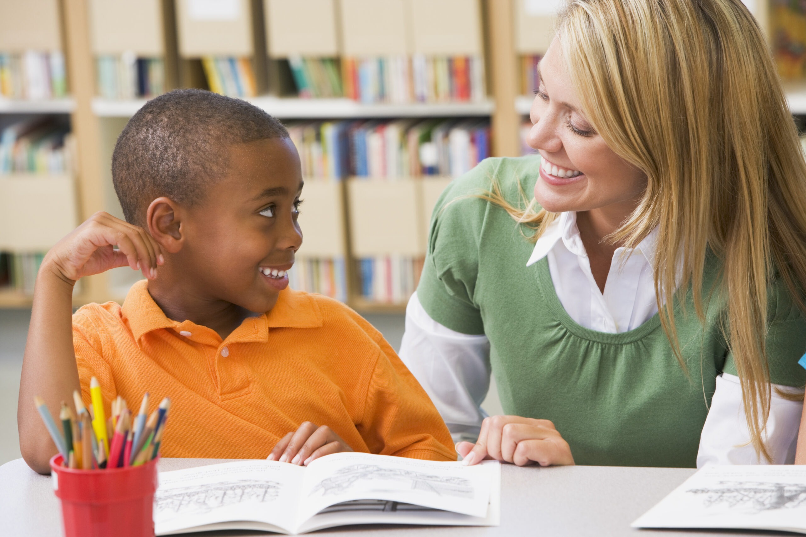 Student In Class Reading with Teacher